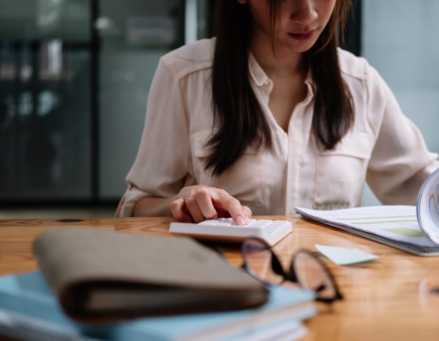Tax deduction planning concept. Accounting woman calculating business balance prepare tax reduction with calcualtor and monthly report.